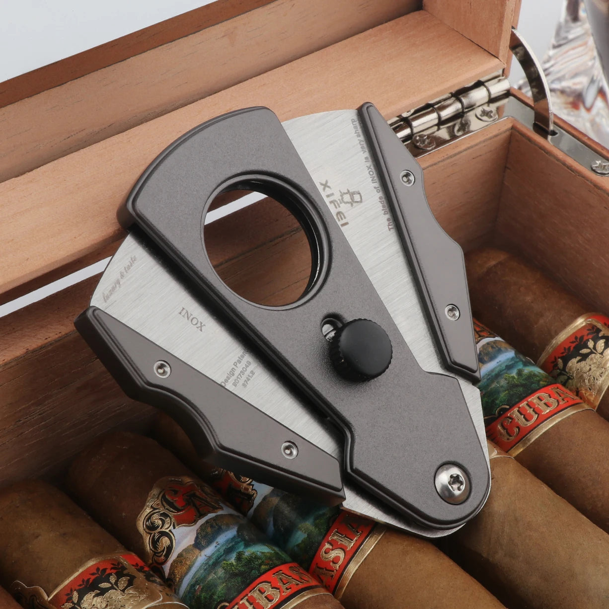 Cigar cutter on a wooden box with cigars