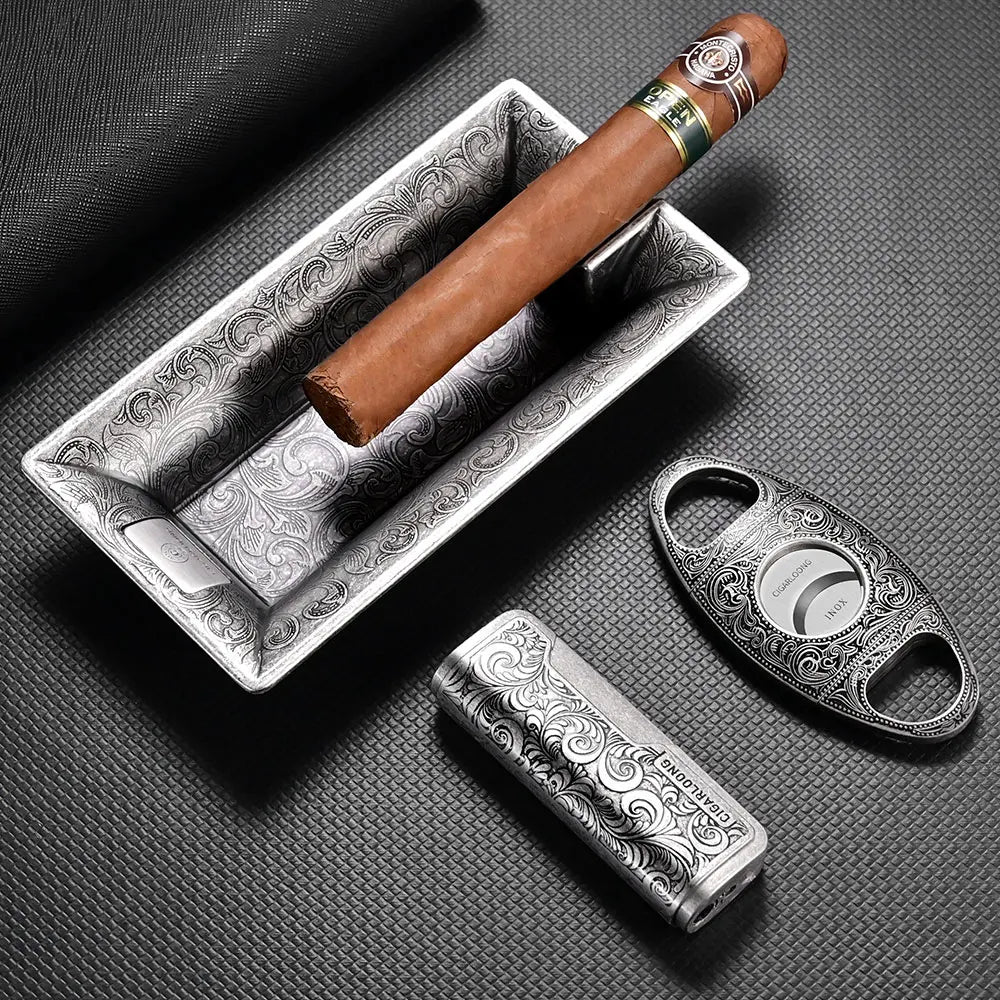 Cigar with a silver ashtray and cutter on a textured surface