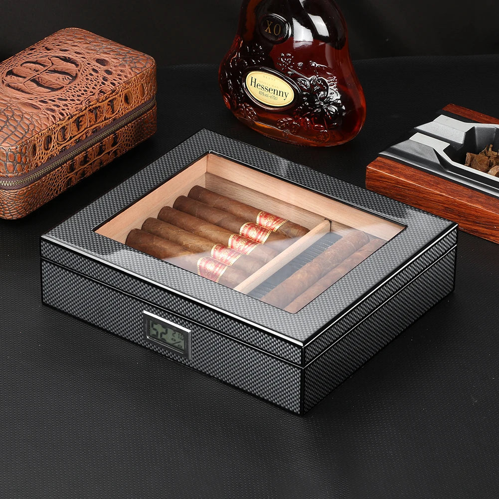 Cigar humidor with cigars, a bottle of Hennessy cognac, and a lighter on a dark surface.