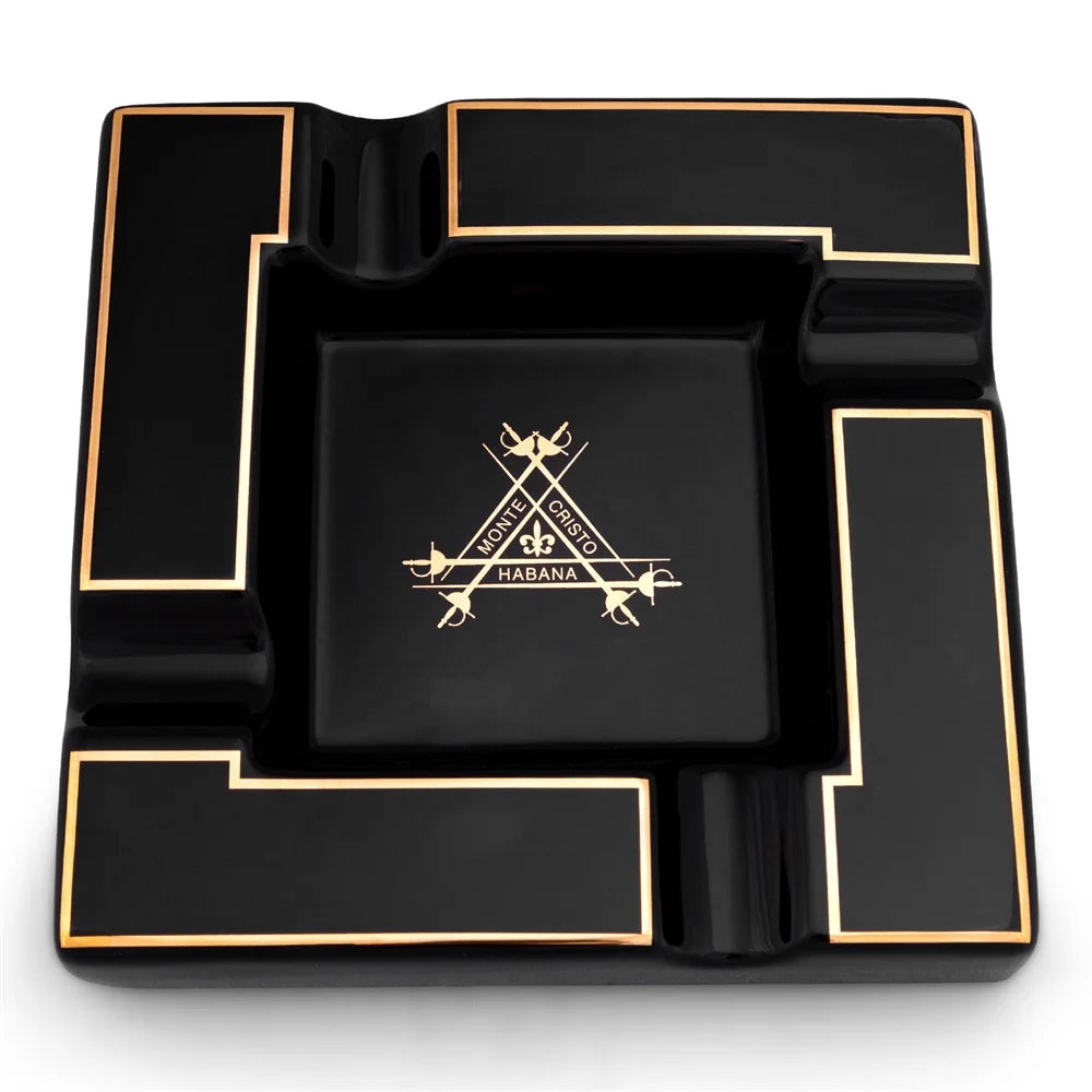 Black ashtray with gold accents and a Monte Cristo logo on a white background