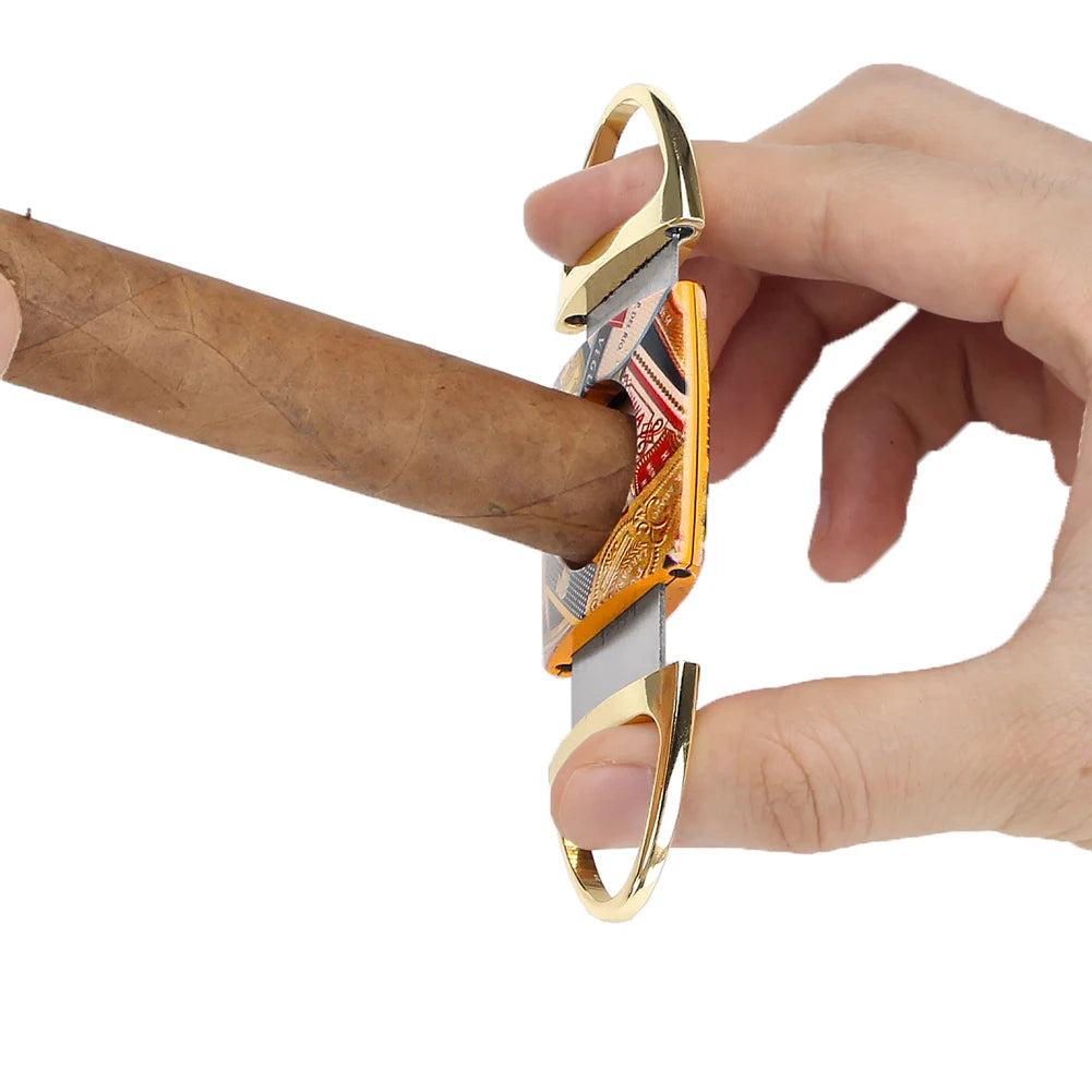 Cigar cutter with gold accents being used to cut a cigar on a white background