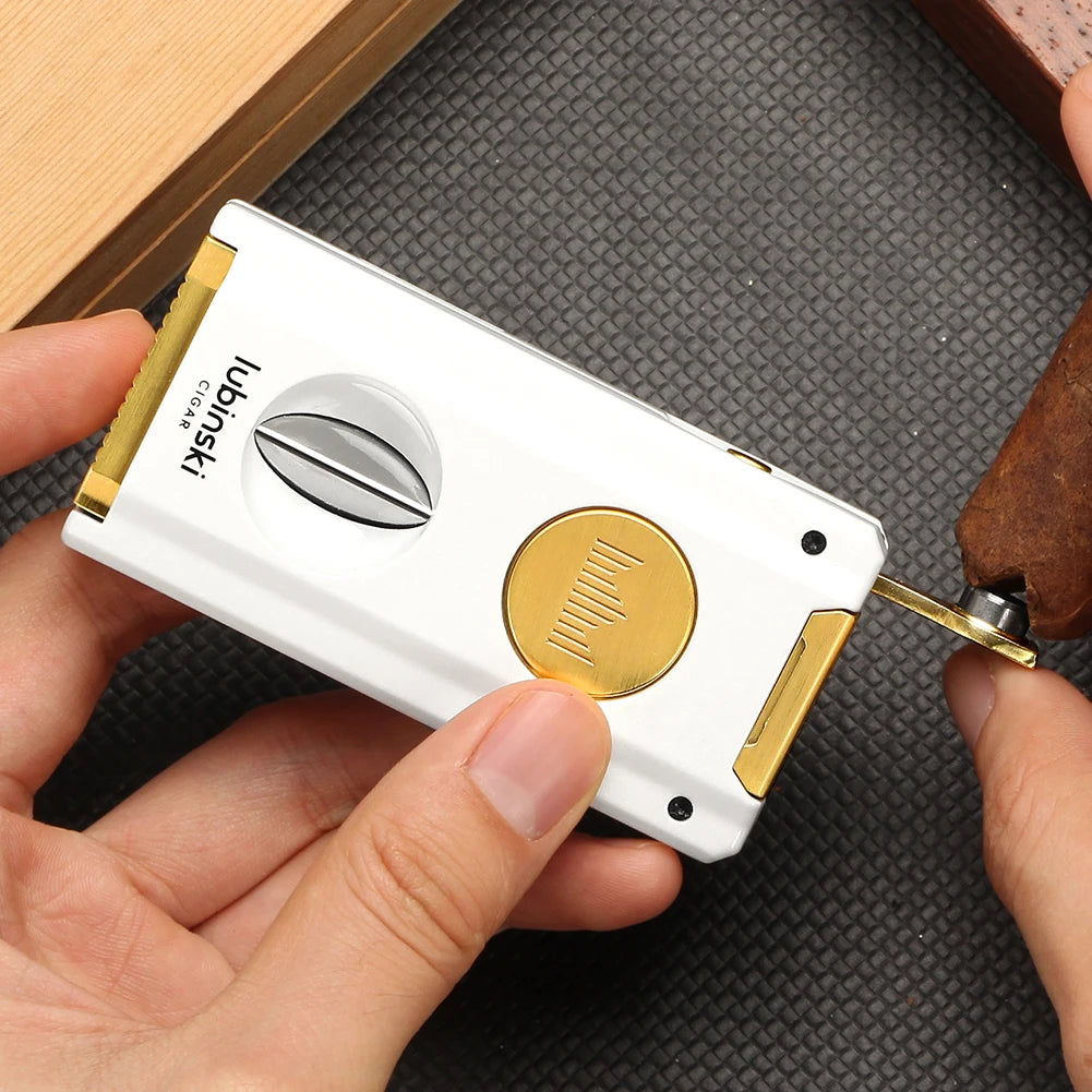 White and gold cigar lighter held by a hand on a textured surface using punch cutter.
