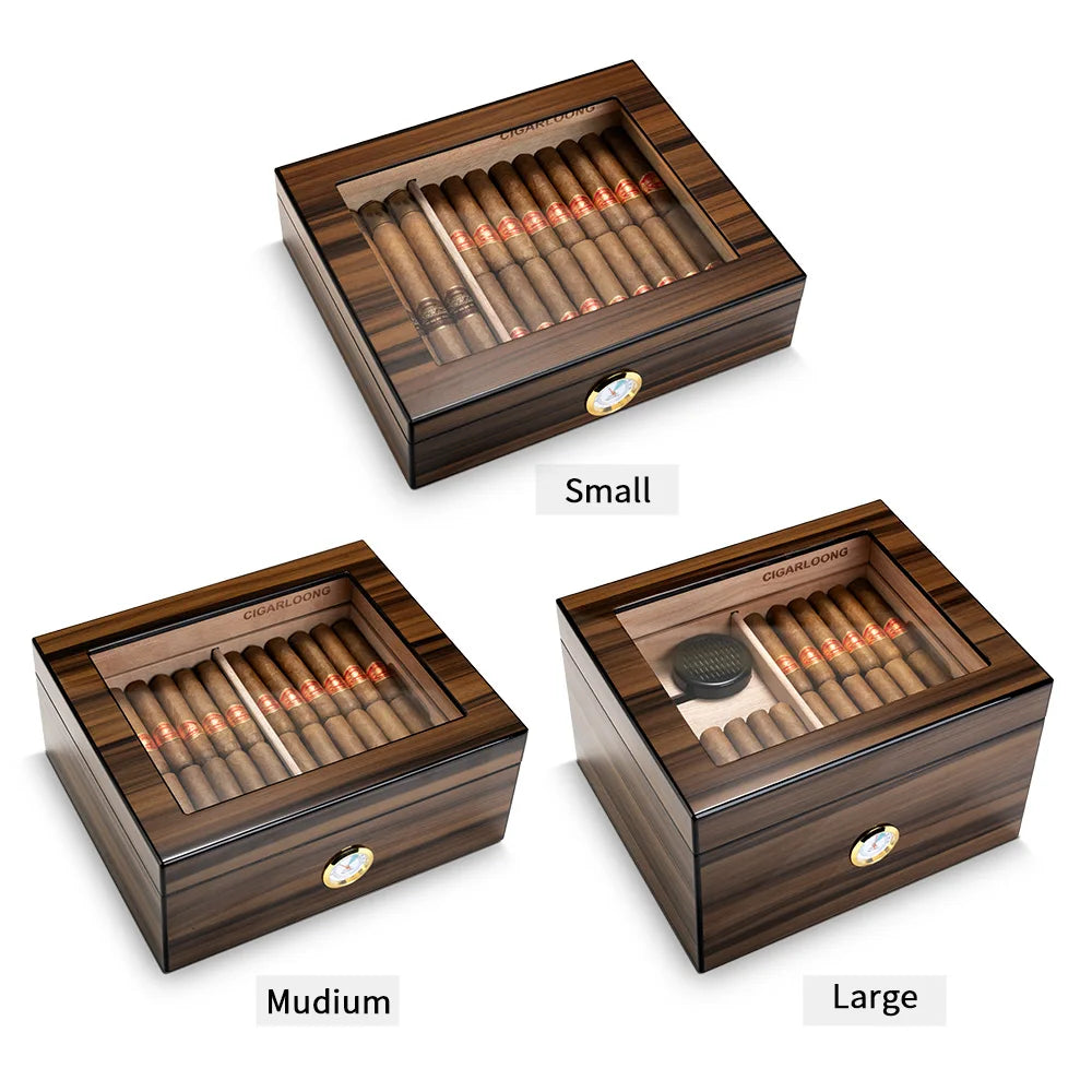 Three wooden cigar humidros of different sizes on a white background