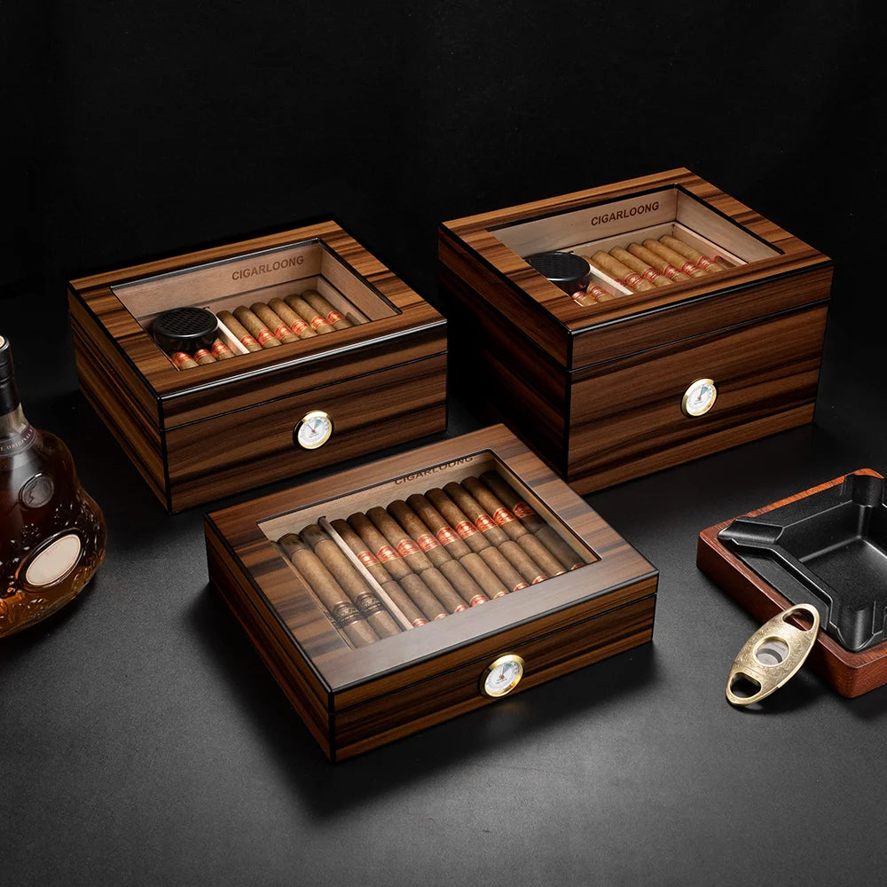 3 spanish cedar humidors with glass tops on a dark surface