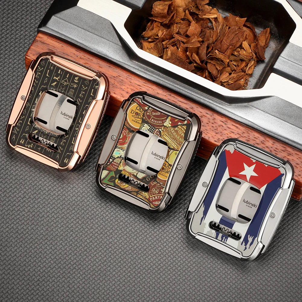 Three cigar cutters with different designs on a textured surface